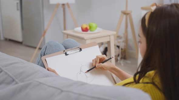 Asian young talented woman artist drawing picture on painting board.