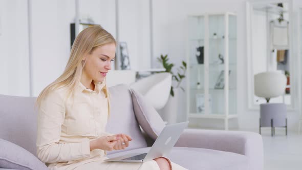 Young attractive woman holding video conference remotely from white room
