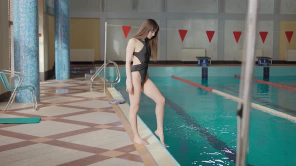 A Beautiful Woman is Standing Near a Large Pool
