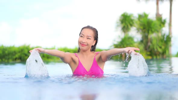 Young asian woman enjoy around outdoor swimming pool for leisure