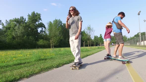 Three cool friends having fun skateboarding