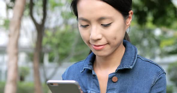 Woman using smart phone in city