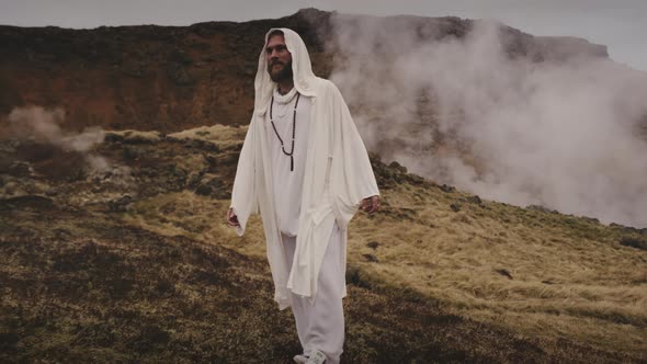 An Adult Man Followed By the Camera As He Wanders in a Mountain Range