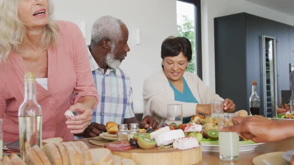 Happy senior diverse people having dinner at retirement home