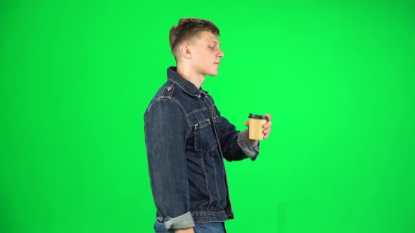 Guy Is Walking and Drinking Coffee From a Paper Cup. Chroma Key. Slow Motion. Side View