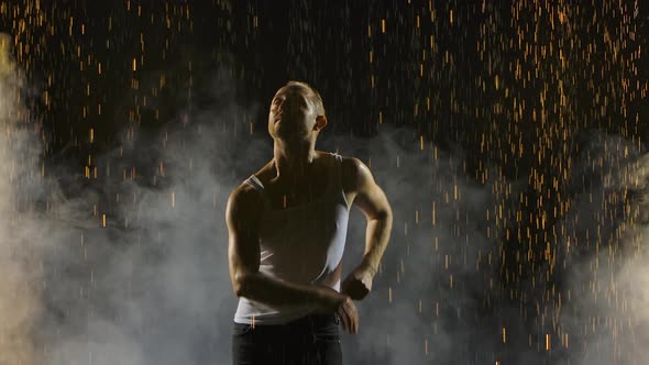 Silhouette of a Male Dancing Salsa on a Background of Shiny Rain Drops. Shot on a Black Smoky Studio