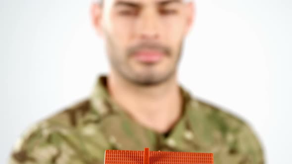 Soldier holding house model on white background