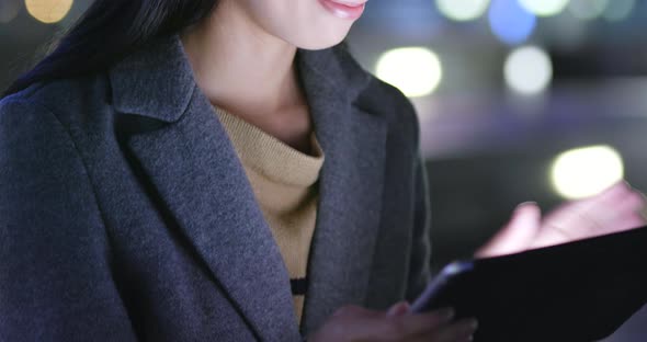 Woman look at tablet computer at night