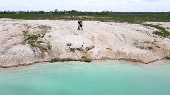 Drone flying low over travel family at lake shore, journey