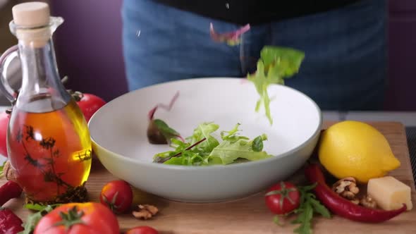 Arugula Salad Leaves Falling Into Ceramic Bowl