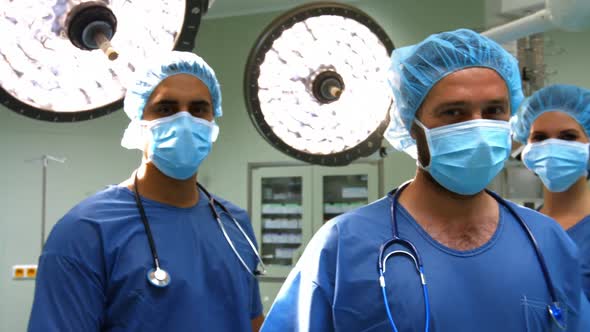 Portrait of male and female surgeons with arms crossed in operation room