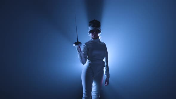 Portrait of Young Woman Fencers Putting on Mask and Getting Into Fighting Position with Sword in Her