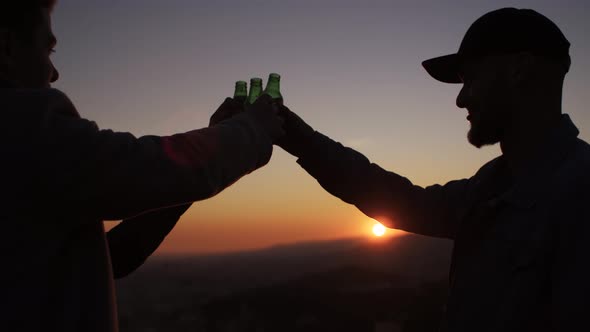 Three friends having a beer at sunset