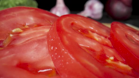 Juicy Sliced Rings of Ripe Red Tomato with Water Drops on Wooden Board