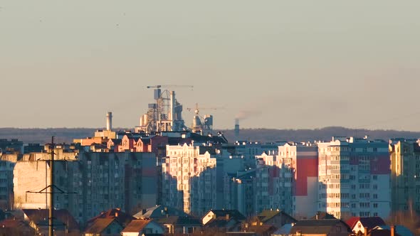 High rise apartment buildings in city residential area and tall factory chimneys with smoke