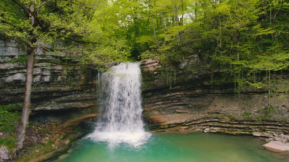 Scenic Drone Shot of a Wonderful Nature  Small Waterfall and a Green Lake