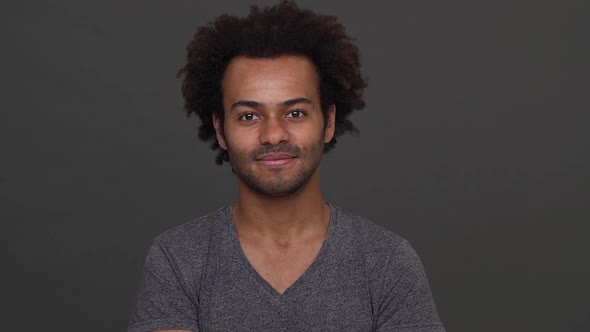 Young African American Boy Cheerly Nodding His Head and Showing Index Finger on Camera Like you are