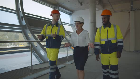 Team of Construction Workers Discussing Project Details with Female Executive Supervisor.