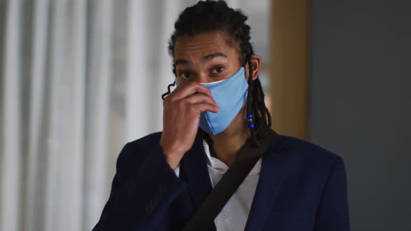 Portrait of mixed race man with dreadlocks wearing blue face mask