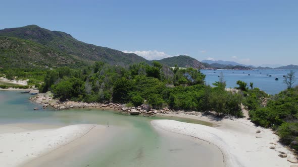 Drone flying above the backwaters and green cliffs around sea of Binh Tien Beach in Vietnam.