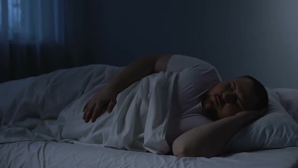 Fat Sleeping Man Tossing in Bed, Health Problem Caused by Excess Weight, Apnoe