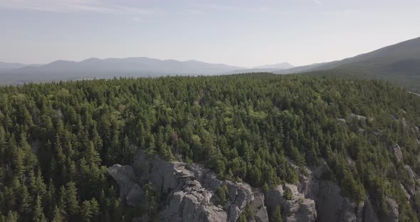 Aerial Drone Shot Flying Away From Mountain Cliff And Forest