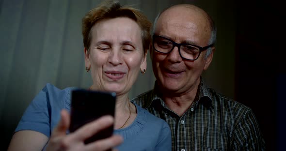 Aged Man and Woman Are Calling By Video Using Cell Phone at Home