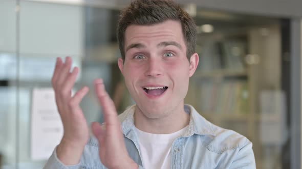 Portrait of Cheerful Young Male Designer Clapping and Smiling