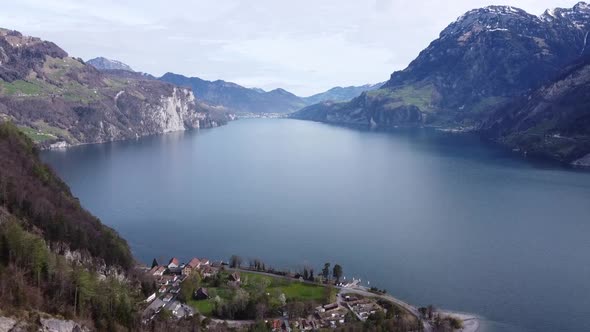 drone flight over the famous deep blue lake uri in the swiss alps, with the small town of Isleten