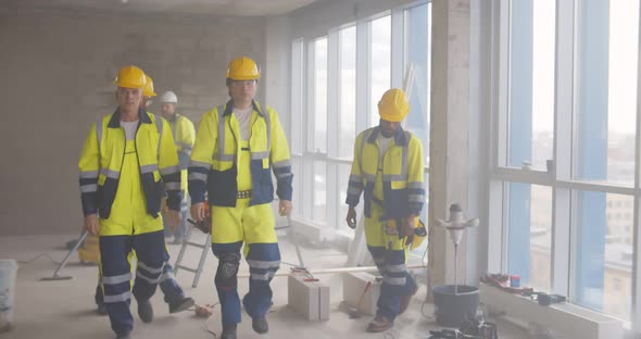 Portrait of Multiethnic Team of Builders in Uniform Posing at Camera on Construction Site