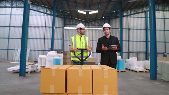 Factory Workers Deliver Boxes Package on a Pushing Trolley in the Warehouse