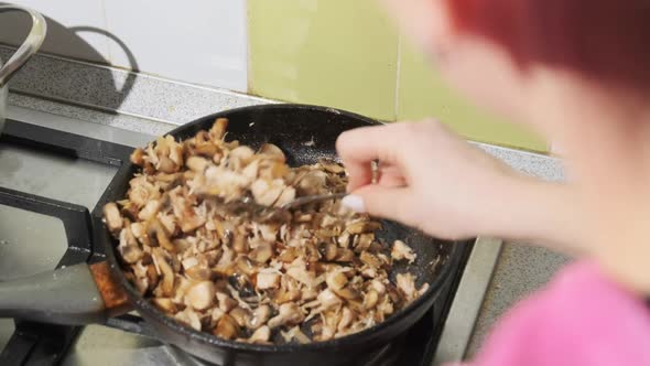 Young Woman Preparing Fried Mushrooms with Cheese and Meat at the Home Kitchen