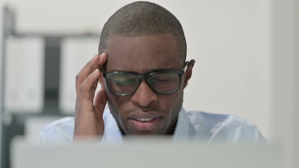 Close Up of African Man Having Headache While Using Laptop