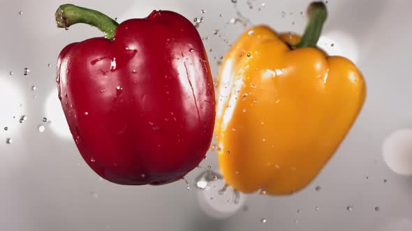 Flying Colored Red and Yellow Peppers Collision in the Air in Slow Motion