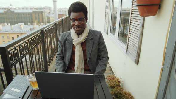 Black Man Web Calling on Laptop on Rooftop Terrace