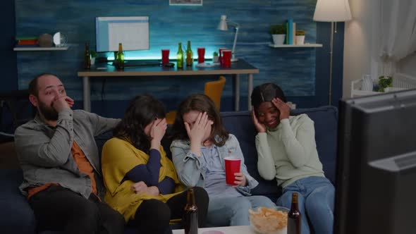 Group of Multiracial People Sitting Comfortable on Couch While Watching Thriller Movie