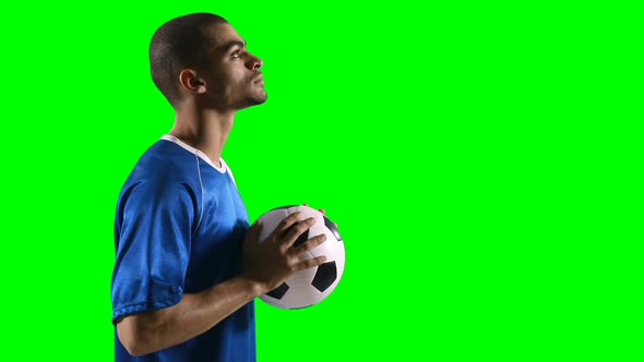 Profile of football player holding a football