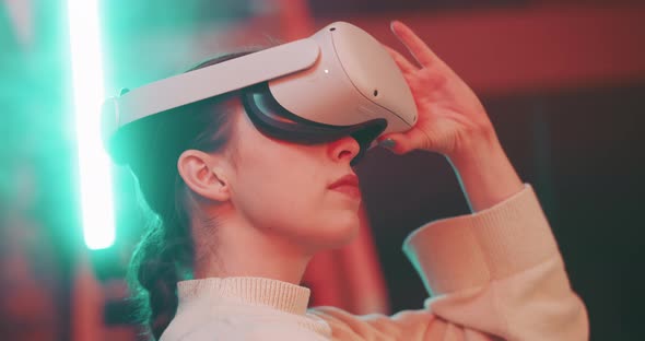 Close up of young woman taking off vr goggles and looking into camera