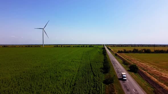 Aerial drone view of a flying over the wind turbine and agricultural fields