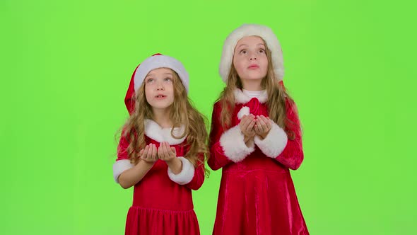 Children Girls in the Christmas Costumes Inflate the Stellar Pollen. Green Screen. Slow Motion