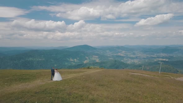 Groom with Bride Walking Together on a Mountain Hills. Aerial Drone Shot