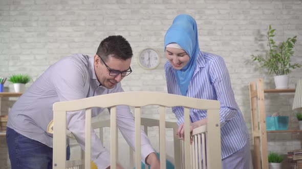 Portrait of a Happy Young Muslim Family with a Newborn Baby at the Children's Bed