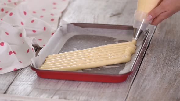 Chef with Confectionery Bag Squeezing Raw Pastry Dough on Tray