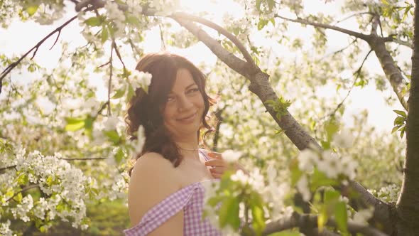 Attractive Woman Near Flowering Tree in Spring Park