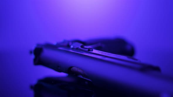 Gun Control. Studio shot of a 9mm gun rotating on a reflective surface