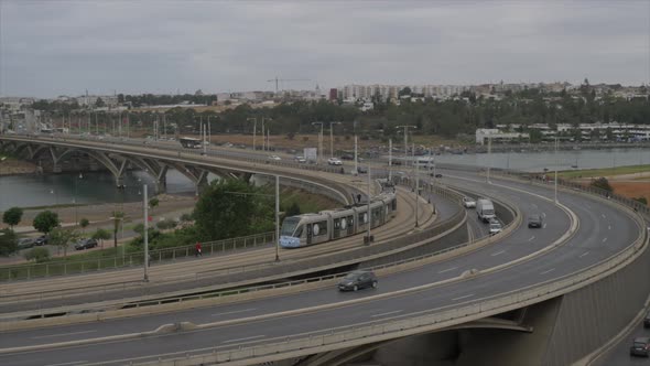 Aerial view of a tram crossing the bridge, along with other vehicles including cars, buses and other