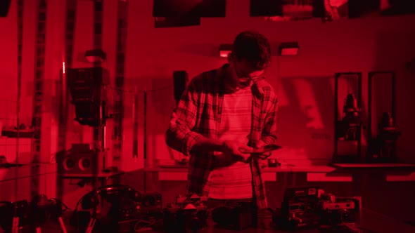 Photographer looking at pictures in a darkroom