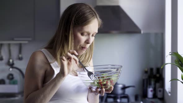 Beautiful Pregnant Woman Eating Salad and Rubbing Belly