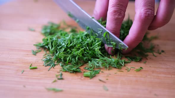 Closeup of Woman Slicing Dill on Wooden Cutting Board  Preparing Ingredient for Meal