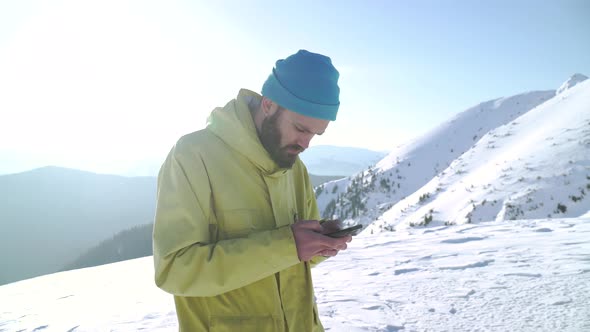 Stylish Bearded Hipster Texting a Message on His Smartphone